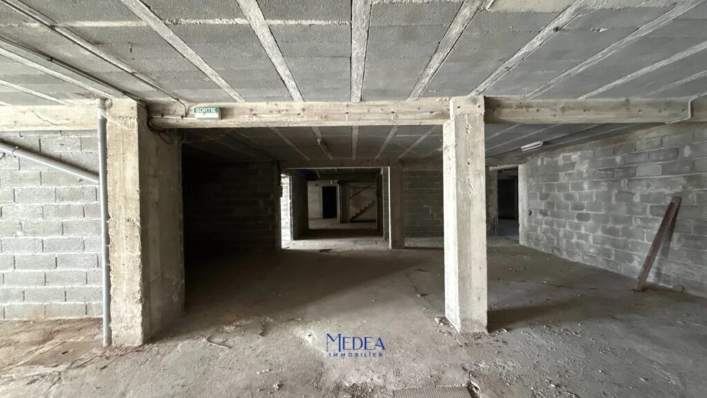 Sous-sol en béton avec murs de blocs de béton et un panneau de sortie