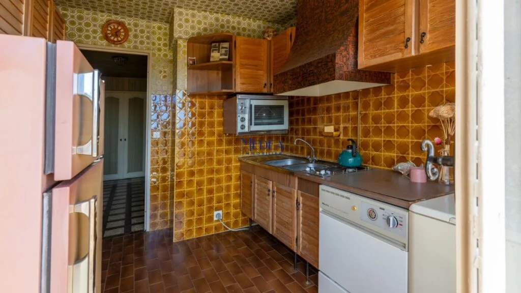 Cuisine vintage avec carrelage marron et réfrigérateur rose