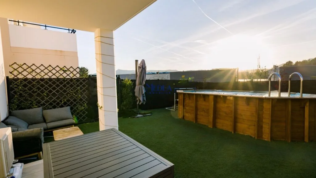 Terrasse avec piscine en bois et mobilier de jardin au coucher du soleil